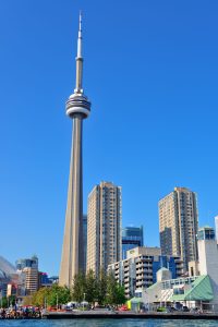 Toronto skyline in the day over lake with urban architecture and blue sky